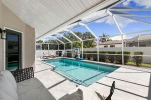 a swimming pool in a house with a patio at Marco Island Beach Home - Heated Pool & Spa in Marco Island
