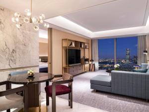 ソウルにあるFairmont Ambassador Seoulのダイニングテーブルとソファのあるリビングルーム