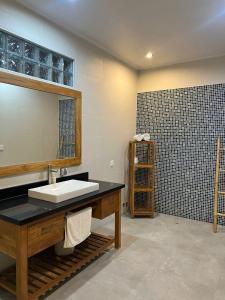 a bathroom with a sink and a mirror at Villa DiKebun in Uluwatu