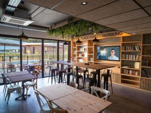 a restaurant with tables and chairs in a library at Greet Hôtel Orthez Bearn in Orthez