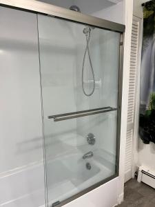 een douche met een glazen omhulsel in een badkamer bij Casino near in Malden +31 foto's