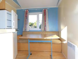 a small kitchen with a table and a window at CAMPING de la BUGE in Rochefort-Montagne +20 photos