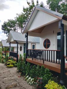 uma pequena casa branca com um alpendre em The white resort & restaurant koh yao yai em Ban Khlong Hia