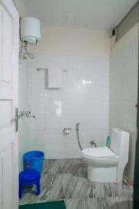 a bathroom with a toilet and a blue stool at HoneyBell Homestay in Darjeeling