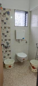 um banheiro com vaso sanitário, pia e janela em Namo Guest House em Daman