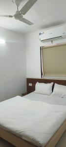 um quarto com uma cama branca com teto em Namo Guest House em Daman mais 7 fotografias