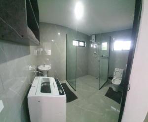 a bathroom with a shower and a sink and a toilet at Lovu Villa in Lautoka