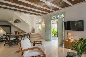 a living room with a table and chairs and a tv at Bodhi Bingin in Uluwatu