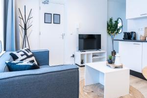 sala de estar con sofá azul y mesa blanca en Fresh And Equipped Apartment Near Hotspots, en Eindhoven
