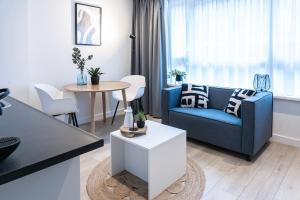 Una sala de estar con un sofá azul y una mesa. en Fresh And Equipped Apartment Near Hotspots, en Eindhoven