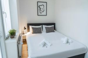 Un dormitorio con una cama blanca y una ventana. en Fresh And Equipped Apartment Near Hotspots, en Eindhoven