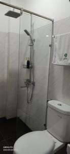 een badkamer met een douche en een wit toilet bij Menoreh Farm Stay Samigaluh Kulonprogo in Kalirejo