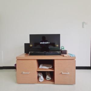 een klein houten kastje met een tv en schoenen erop bij Menoreh Farm Stay Samigaluh Kulonprogo in Kalirejo +7 foto's