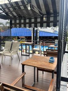 a deck with chairs and a table and a boat at White Monkey Guesthouse in Phetchaburi