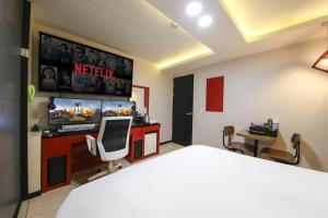 a bedroom with a bed and a tv and a desk at 전주 코자자모텔 