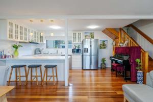 een keuken met een aanrecht en een bar met krukken bij Tenby Point Waterfront Views & Tranquil Garden in Queensferry