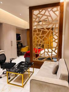 un salon avec un canapé et une table dans l'établissement Blue Sapphire Forest Stays, à Ghaziabad