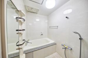 een badkamer met een bad, een wastafel en een douche bij ホワイトヒルズ in Tomigusuku +30 foto's