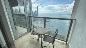 a balcony with a table and chairs and the ocean at Apartamento en Panama, Yoo and Art eAvenida Balboa in Panama City