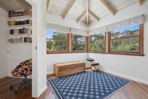 Una habitación con un escritorio y una silla y ventanas. en The Mud Brick House, en Leura