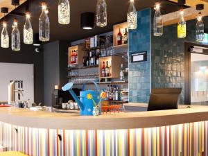 a bar with a counter with a sink and a bartender at greet Wien City Nord in Vienna