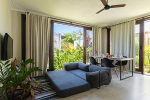 a living room with a blue couch and a table at Casa incrível e aconchegante em Barra Grande - BA, Ponta do Mutá, em condomínio com excelente localização à 5 minutos da PRAIA e dos melhores BEACH CLUBS, próximo ao charmoso centrinho de Barra Grande e comércios in Marau