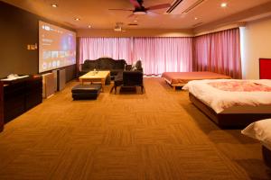 a hotel room with two beds and a flat screen tv at 熱海の隠れ里 in Atami +40 photos