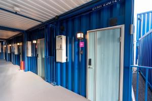 勝浦市にあるHOTEL R9 The Yard Katsuraのドアが開いた建物の青い壁