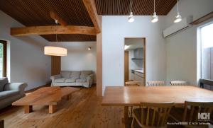 a dining room and living room with a wooden table at 居里ステイ in Shimabara
