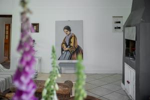 une peinture d'une femme sur un mur dans un salon dans l'établissement Galileo Farm, à Elgin