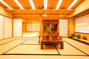 a room with a table and a projection screen at 熱海の隠れ里 in Atami