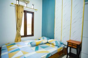 een slaapkamer met een bed en een raam bij O2 Jogja Villa in Salakan