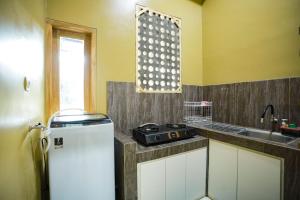 een kleine keuken met een spoelbak en een koelkast bij O2 Jogja Villa in Salakan