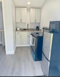 a kitchen with white cabinets and a blue refrigerator at Hidden Treasure in Davenport