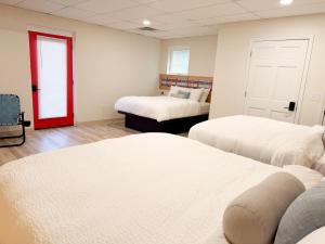 a room with two beds and a red door at Explorer Rest & Recreation in Sandusky