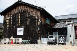 eine Scheune mit zwei davor geparkten Lastwagen in der Unterkunft Rockstar Villa 江井浜STYLE in Awaji