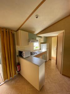 een kleine keuken met een fornuis en een aanrecht bij CAMPING de la BUGE in Rochefort-Montagne