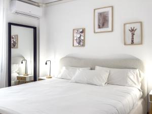 une chambre blanche avec un grand lit avec des oreillers blancs dans l'établissement Hanami Avenida de España Beach Front - Mountain View, à Estepona