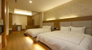 a hotel room with two beds and a television at 山水聽風會館 in Yuanshan +26 photos