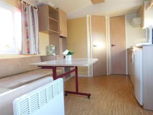 een kleine keuken met een tafel en een koelkast bij CAMPING de la BUGE in Rochefort-Montagne +24 foto's