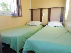 two beds sitting next to each other in a room at CAMPING de la BUGE in Rochefort-Montagne