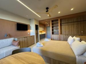 パノルモス・レティムノにあるPhiloxenia Apartmentsのベッドとソファのあるホテルの部屋