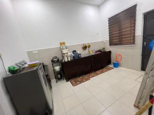 a kitchen with a table in the middle of a room at Hasya Guesthouse in Seri Iskandar