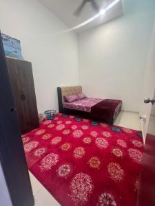 a room with a bed and a red rug at Hasya Guesthouse in Seri Iskandar