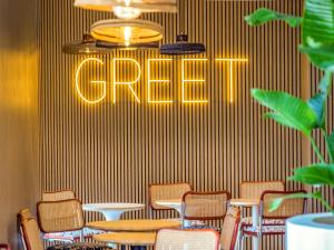Un restaurante con sillas y una mesa y un cartel que dice cangrejo. en greet hotel Salon de Provence, en Salon-de-Provence