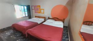 a room with two beds and a window at Gokarna Holiday Homes in Gokarna