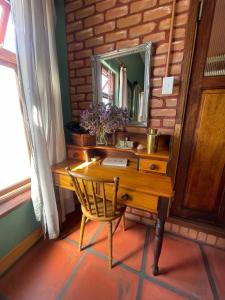 a wooden desk with a mirror and a chair at Bokmakierie Studio in Montagu +7 photos