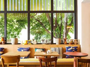 un restaurante con 2 mesas y una gran ventana en greet hotel Marseille Parc Chanot Velodrome, en Marsella