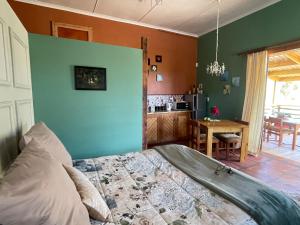 a bedroom with green and orange walls and a bed at Bokmakierie Studio in Montagu