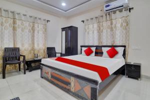 a bedroom with a large bed with red pillows at Hotel O Shri Ganesh Near By Himayatnagar,Ashok Nagar,RTC X Roads in Hyderabad